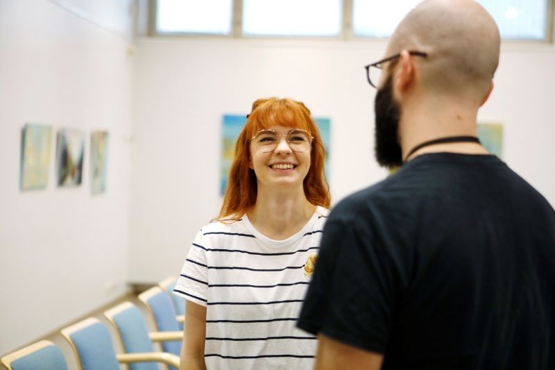 Nainen hymyilee edessään seisovalle miehelle.