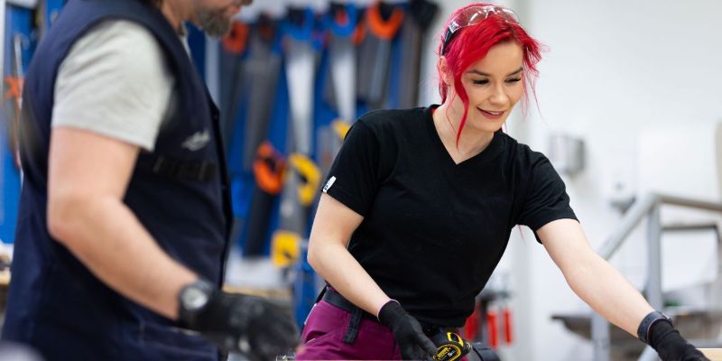 Kaksi henkilöä tekee puutöitä. 