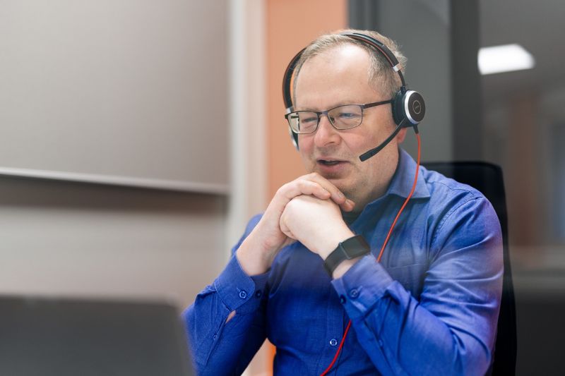 Mies silmälaseissa sekä kuulokkeet päässä.