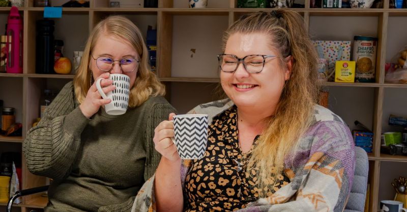 Kaksi henkilöä kahvin äärellä.