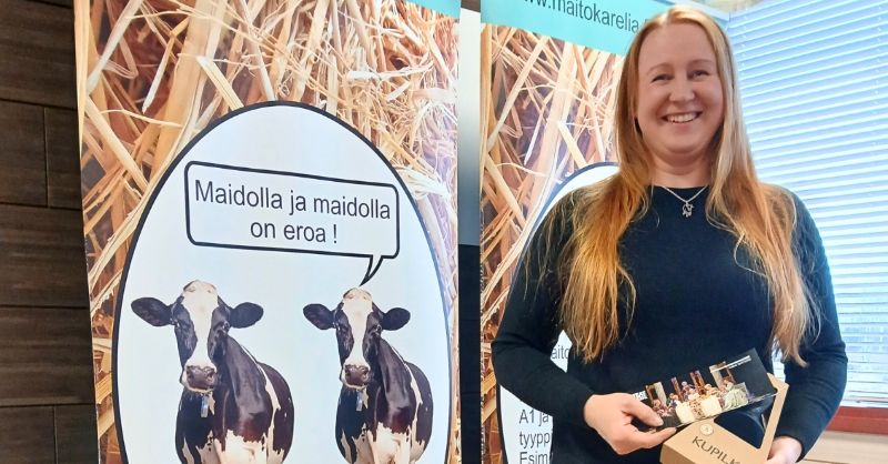 Palkinnon arvonnan voittaja Outi Hännikäinen näyttää palkintoja.