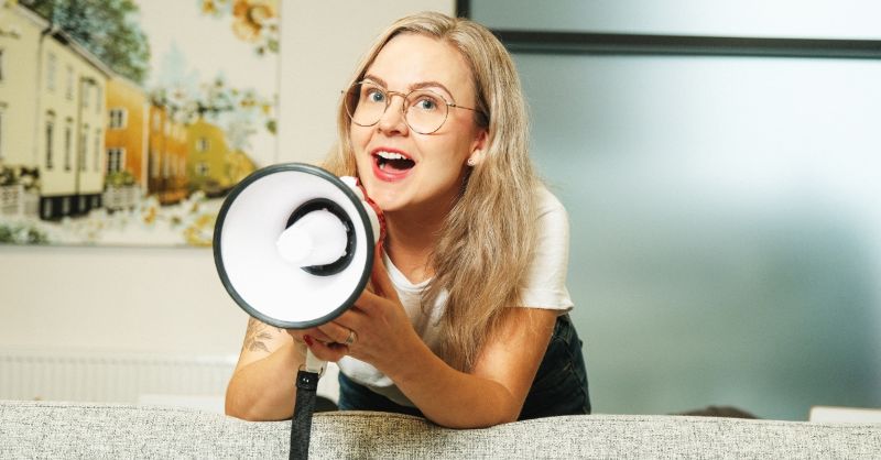 Nainen huutaa megafoniin.