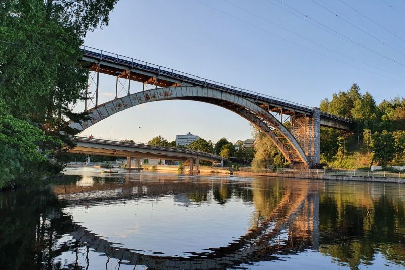 Kuva Heinolan kaarisillasta, mukana järvimaisemaa ja puita.