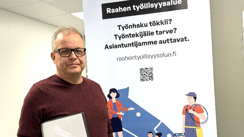 Koordinoiva asiantuntija Marko Salmela. Taustalla Raahen työllisyysalueen roll up -juliste.