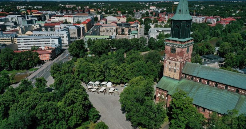Ilmakuva Turun tuomiokirkosta, kirkkopuistosta ja tuomiokirkon aukiosta, jossa on ravintola-alue.